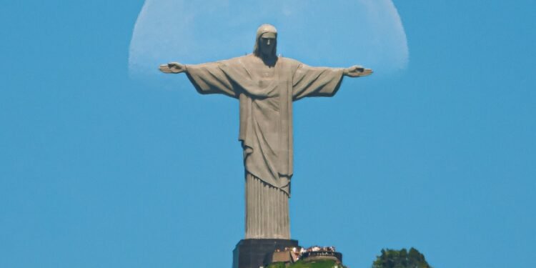 Com céu claro, fotógrafo registra lua ‘abraçando’ o Cristo