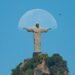 Com céu claro, fotógrafo registra lua ‘abraçando’ o Cristo